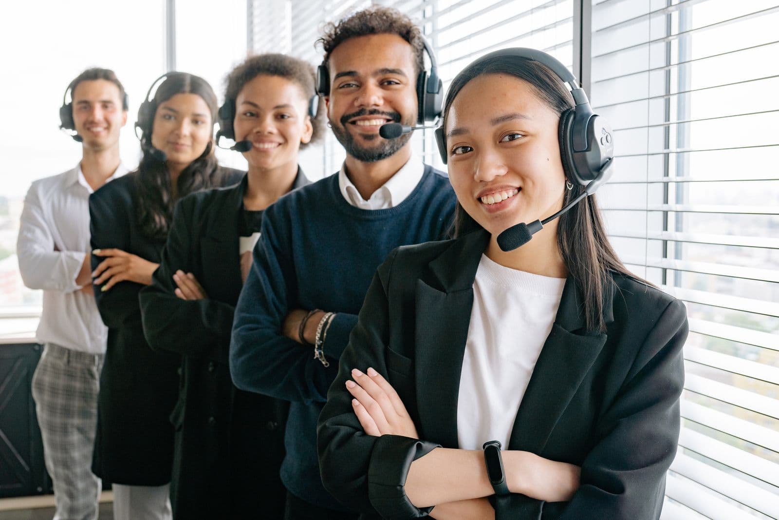 Friendly insurance agents with headsets ready to take calls in an office