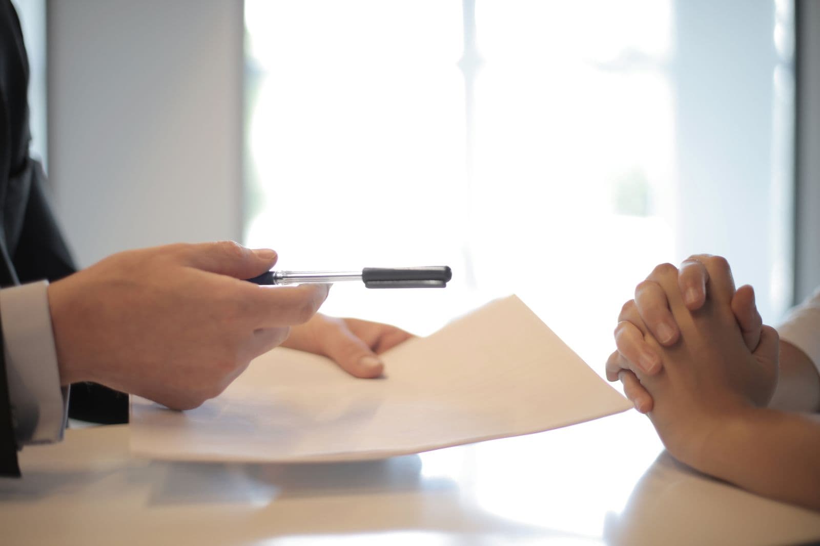 An agent walking a customer through insurance paperwork at a desk